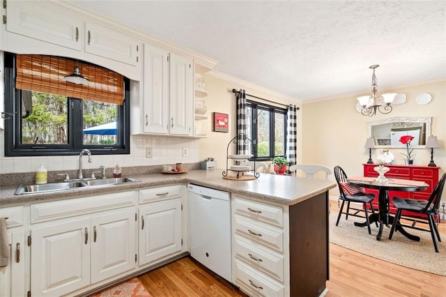 kitchen featuring pendant lighting, white cabinets, dishwasher, and a peninsula