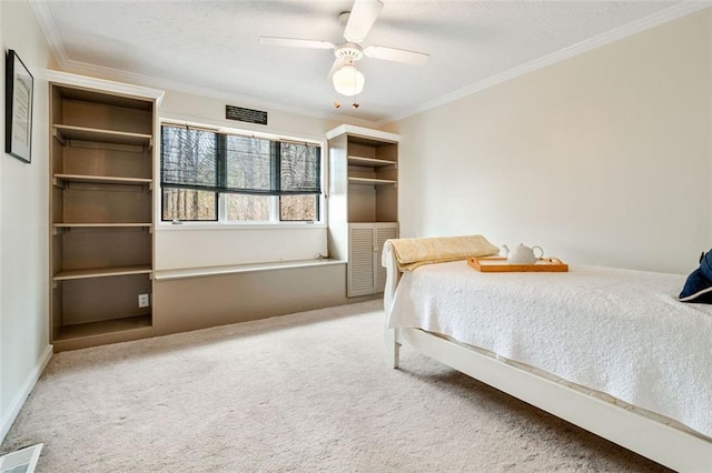 unfurnished bedroom with carpet floors, ornamental molding, visible vents, and a ceiling fan