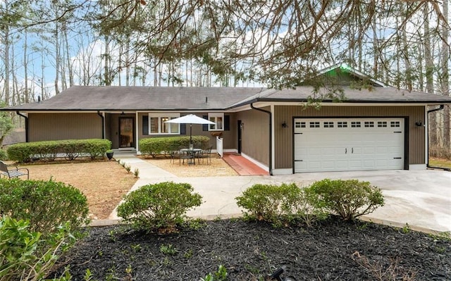 ranch-style home with a garage, a patio area, and driveway