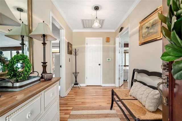 foyer featuring baseboards, light wood-type flooring, visible vents, and crown molding