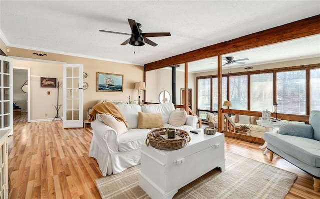 living room with light wood-type flooring, a textured ceiling, a wealth of natural light, and french doors