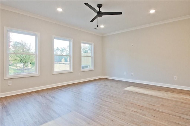 empty room with plenty of natural light, light hardwood / wood-style floors, and crown molding