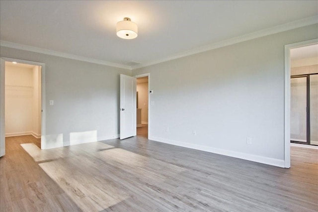 spare room featuring wood-type flooring and ornamental molding