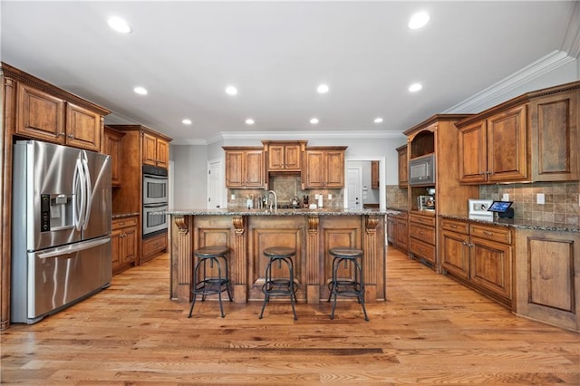 2517 Stone Manor Dr, Buford, GA 30519 - kitchen featuring stainless steel appliances, crown molding, light wood finished floors, a kitchen bar, and tasteful backsplash