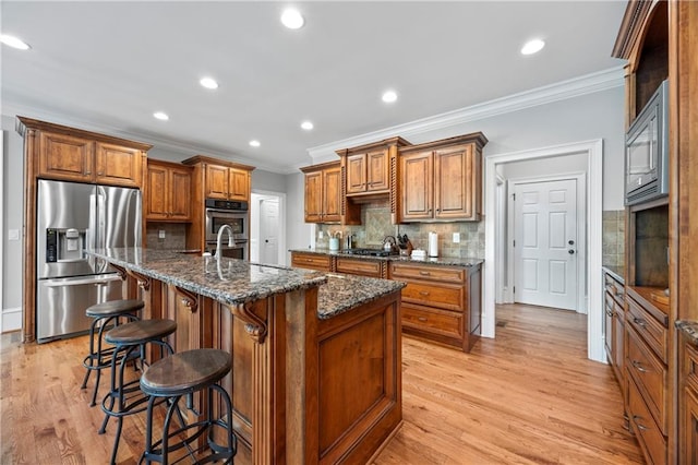 2517 Stone Manor Dr, Buford, GA 30519 - kitchen with stainless steel appliances, crown molding, brown cabinetry, decorative backsplash, and recessed lighting