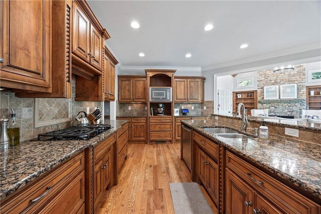 2517 Stone Manor Dr, Buford, GA 30519 - kitchen featuring a sink, stainless steel appliances, brown cabinetry, light wood-style floors, and ornamental molding