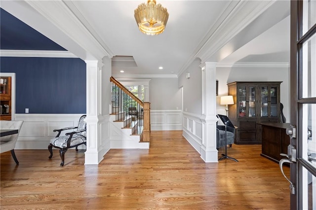 2517 Stone Manor Dr, Buford, GA 30519 - foyer featuring decorative columns, stairs, wood finished floors, a decorative wall, and a wainscoted wall