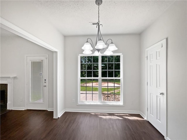 63 Couch Rd, Senoia, GA 30276 - unfurnished dining area with dark wood-style flooring, a chandelier, a textured ceiling, baseboards, and a high end fireplace