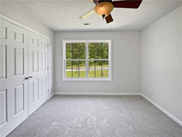 63 Couch Rd, Senoia, GA 30276 - unfurnished bedroom with carpet, baseboards, a closet, a textured ceiling, and a ceiling fan