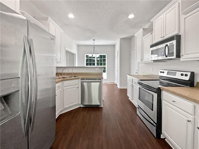 63 Couch Rd, Senoia, GA 30276 - kitchen with stainless steel appliances, a sink, a chandelier, dark wood-style flooring, and white cabinets