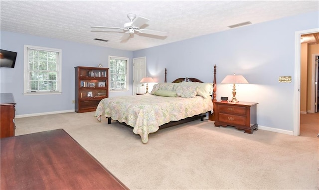 carpeted bedroom featuring a textured ceiling and ceiling fan