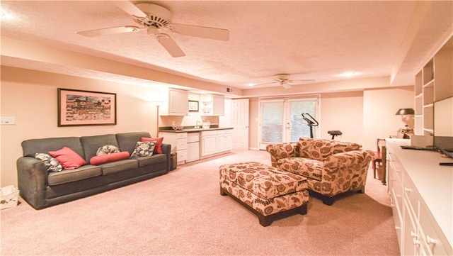 living room featuring light carpet, a textured ceiling, sink, and ceiling fan