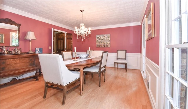 dining area with crown molding, light hardwood / wood-style flooring, plenty of natural light, and an inviting chandelier