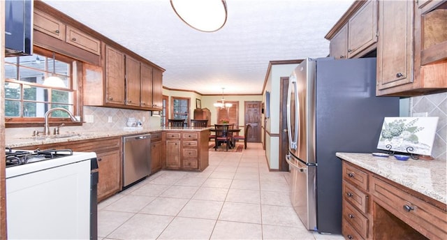 kitchen featuring sink, stainless steel appliances, pendant lighting, crown molding, and decorative backsplash