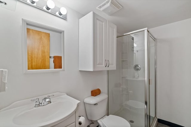 bathroom with vanity, toilet, and a shower with door