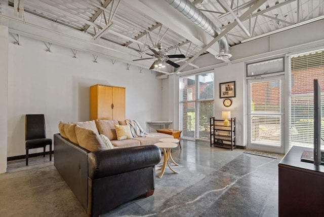 living room featuring a high ceiling, concrete floors, and ceiling fan