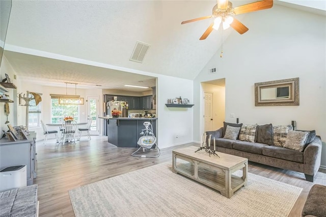 260 Brannon Dr, Hoschton, GA 30548 - living area with light wood-style flooring, ceiling fan, high vaulted ceiling, and baseboards