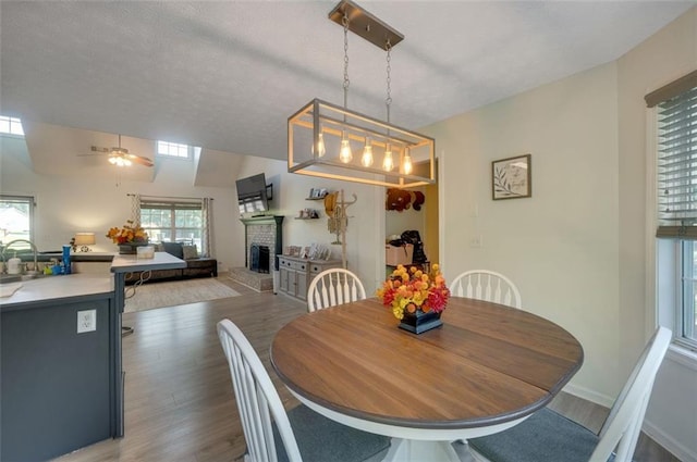 260 Brannon Dr, Hoschton, GA 30548 - dining space featuring a fireplace, wood finished floors, and ceiling fan