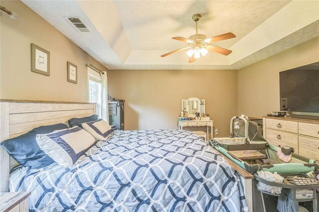 260 Brannon Dr, Hoschton, GA 30548 - bedroom featuring a tray ceiling, a textured ceiling, and a ceiling fan