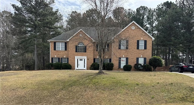 colonial inspired home with brick siding and a front lawn