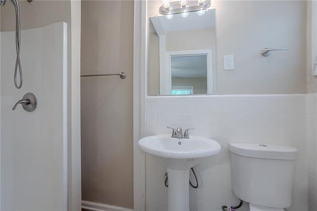 2755 Rockcliff Rd SE, Atlanta, GA 30316 - bathroom with tile walls, a shower, toilet, and a wainscoted wall
