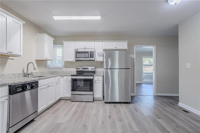 2755 Rockcliff Rd SE, Atlanta, GA 30316 - kitchen featuring appliances with stainless steel finishes, a sink, healthy amount of natural light, and white cabinetry