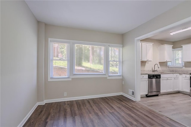 2755 Rockcliff Rd SE, Atlanta, GA 30316 - kitchen featuring stainless steel dishwasher, light wood-style floors, white cabinetry, and a sink