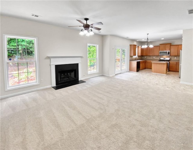 unfurnished living room with a healthy amount of sunlight and light colored carpet