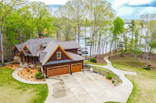 view of front of house with a water view, a garage, and a front lawn