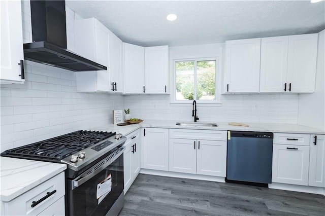 kitchen featuring wood finished floors, a sink, stainless steel gas range, dishwasher, and wall chimney exhaust hood