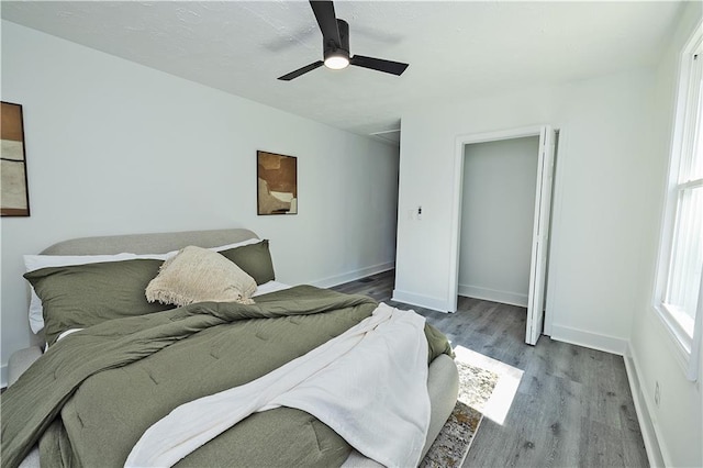 bedroom featuring ceiling fan, wood finished floors, and baseboards