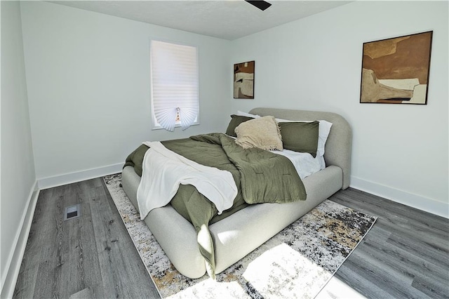 bedroom featuring visible vents, baseboards, and wood finished floors