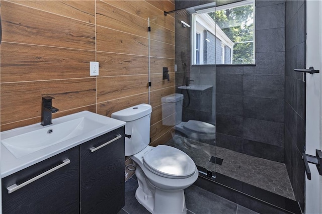 bathroom featuring toilet, wooden walls, walk in shower, and vanity