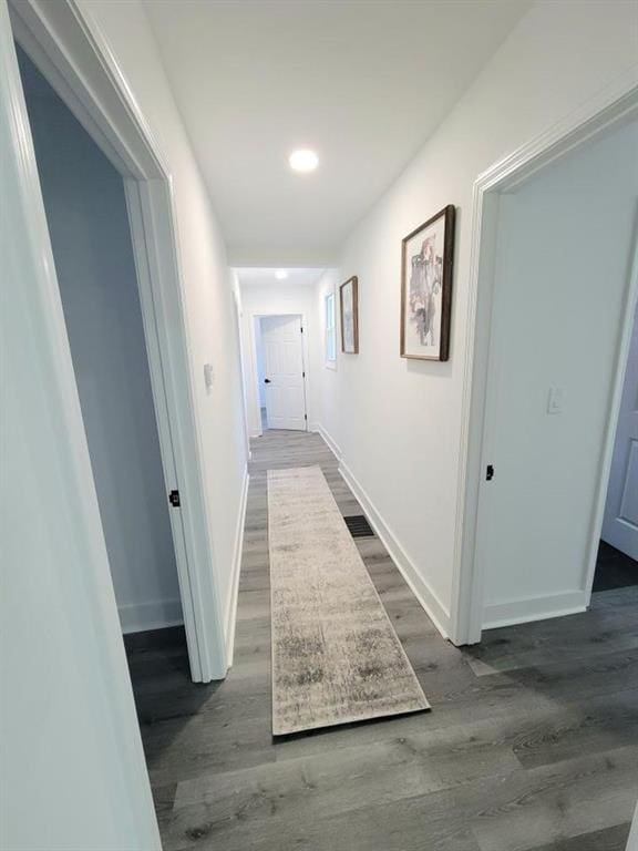 hall with recessed lighting, wood finished floors, and baseboards