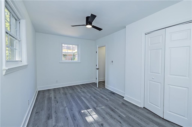 unfurnished bedroom featuring ceiling fan, a closet, wood finished floors, and baseboards