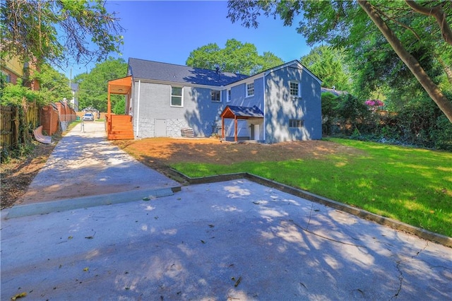 view of front of house with driveway, fence, and a front yard