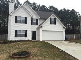 traditional home featuring a garage, driveway, and a front lawn