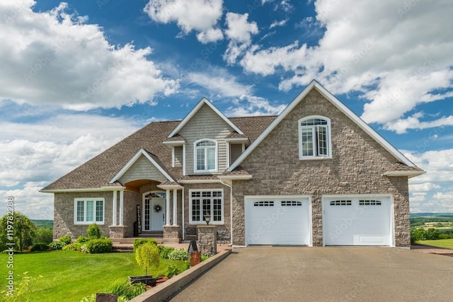 craftsman house with driveway, a front lawn, roof with shingles, and an attached garage