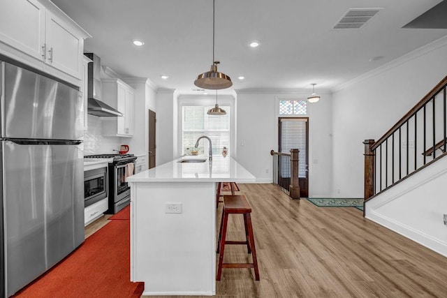 4565 Sims Park Ovlk, Suwanee, GA 30024 - kitchen featuring stainless steel appliances, wall chimney exhaust hood, a sink, ornamental molding, and a kitchen bar