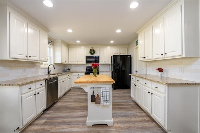 kitchen with black appliances, wood counters, white cabinets, and a sink