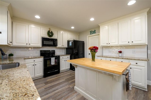 kitchen with white cabinets, dark wood-type flooring, black appliances, wooden counters, and a sink