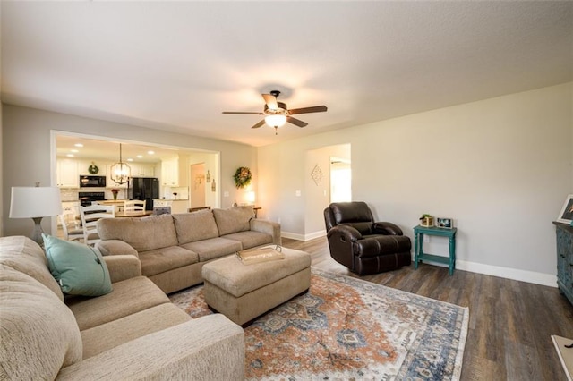 living room featuring wood finished floors, a ceiling fan, and baseboards