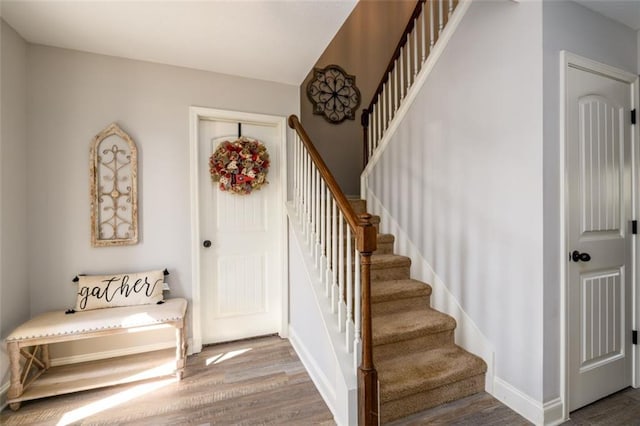 stairs with wood finished floors and baseboards