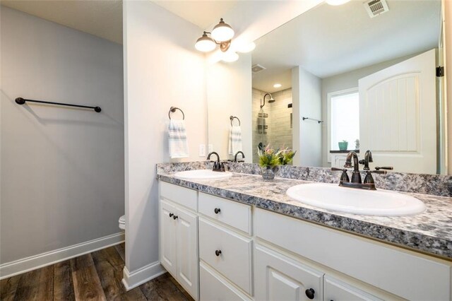 full bath with visible vents, a sink, a shower stall, and toilet