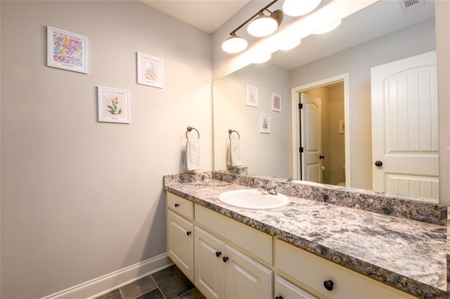 bathroom featuring visible vents, vanity, baseboards, and tile patterned floors