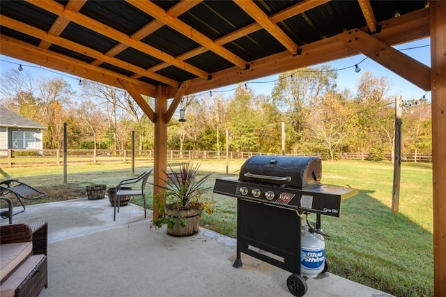 view of patio featuring a grill and fence