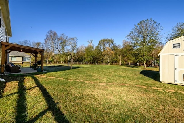 view of yard featuring an outbuilding, a patio, a storage shed, and fence