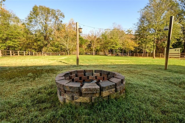 view of yard with an outdoor fire pit and fence