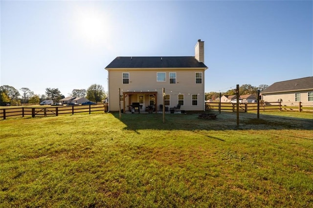 rear view of property featuring a fenced backyard, a chimney, and a lawn