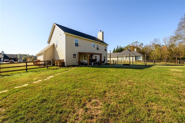 back of property featuring a chimney, fence, and a lawn